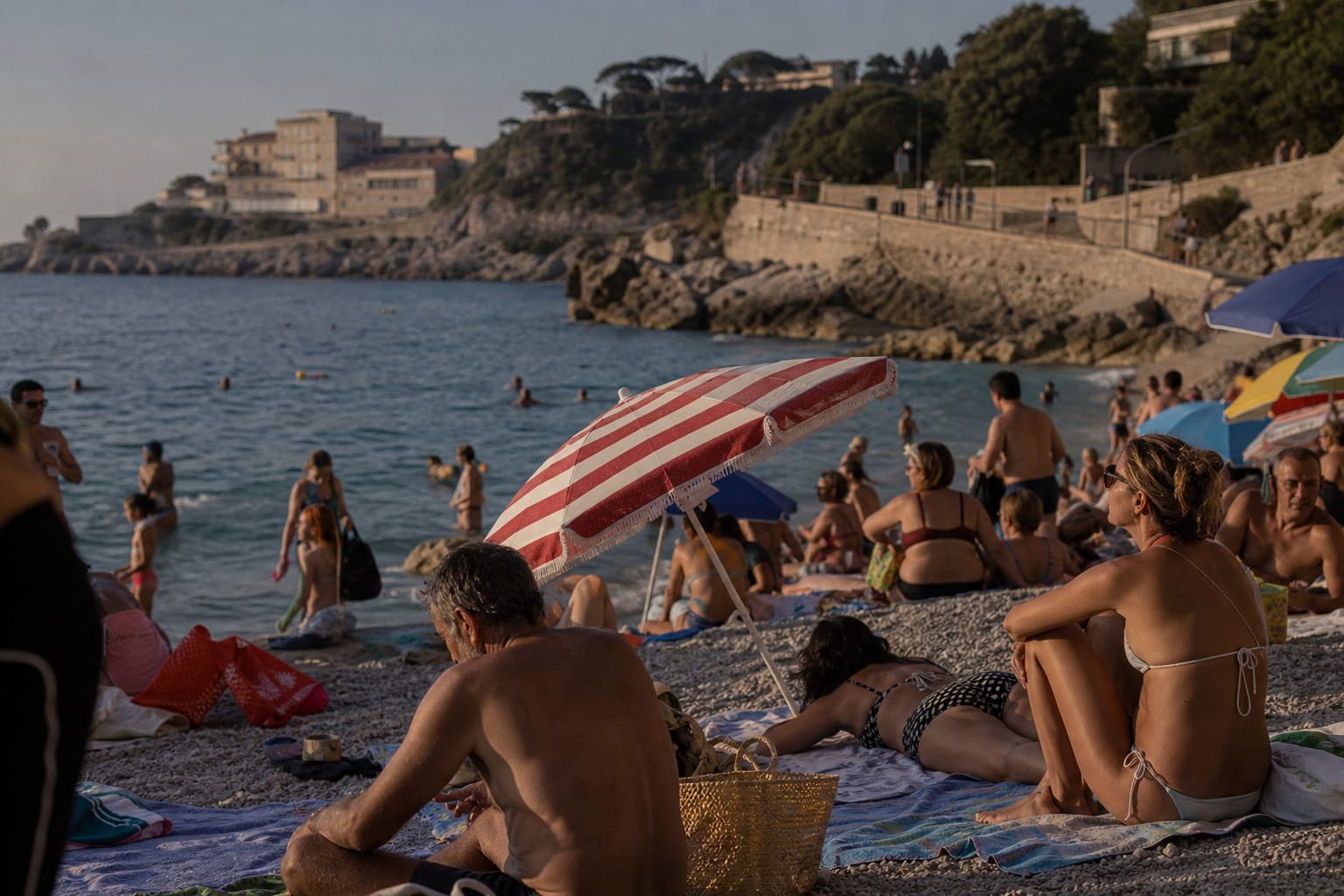 Plage animée en fin de journée avec baigneurs et parasols